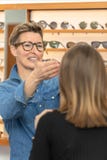 Mujer en una tienda de las gafas foto de archivo Mujer en una tienda de las gafas foto de archivo