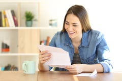 Mujer feliz que lee una letra en casa foto de archivo libre de regalías Mujer feliz que lee una letra en casa foto de archivo libre de regalías