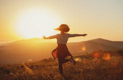Mujer feliz que salta y que disfruta de vida en la puesta del sol en montañas Imagenes de archivo Mujer feliz que salta y que disfruta de vida en la puesta del sol en montañas Imagenes de archivo