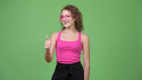 Mujer hermosa feliz joven del empollón que da los pulgares para arriba almacen de video Mujer hermosa feliz joven del empollón que da los pulgares para arriba almacen de video