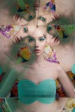 Mujer hermosa joven con maquillaje brillante del colorfull en fondo de la flor fotografía de archivo libre de regalías Mujer hermosa joven con maquillaje brillante del colorfull en fondo de la flor fotografía de archivo libre de regalías