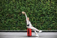 Mujer hermosa joven en aeropuerto contra la pared verde fotografía de archivo libre de regalías Mujer hermosa joven en aeropuerto contra la pared verde fotografía de archivo libre de regalías