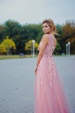 Mujer hermosa joven en trayectoria que camina rosada larga del vestido de noche en parque Forme el retrato del estilo de la mucha foto de archivo libre de regalías Mujer hermosa joven en trayectoria que camina rosada larga del vestido de noche en parque Forme el retrato del estilo de la mucha foto de archivo libre de regalías
