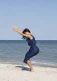 Mujer hermosa joven que hace yoga en la playa en vestido azul imagen de archivo libre de regalías Mujer hermosa joven que hace yoga en la playa en vestido azul imagen de archivo libre de regalías