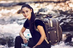 Mujer hermosa que descansa sobre una roca en el río y el wate de consumición imágenes de archivo libres de regalías Mujer hermosa que descansa sobre una roca en el río y el wate de consumición imágenes de archivo libres de regalías