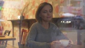 Mujer hermosa que disfruta de la bebida caliente, soñando sobre futuro y haciendo planes almacen de metraje de vídeo Mujer hermosa que disfruta de la bebida caliente, soñando sobre futuro y haciendo planes almacen de metraje de vídeo