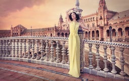Mujer hermosa que lleva el vestido amarillo largo Foto de archivo libre de regalías Mujer hermosa que lleva el vestido amarillo largo Foto de archivo libre de regalías