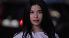 Mujer hermosa que mira la cámara la noche almacen de video Mujer hermosa que mira la cámara la noche almacen de video