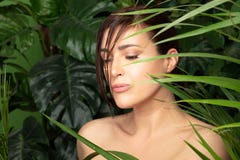 Mujer hermosa rodeada por las plantas verdes Concepto del balneario y tratamiento natural del skincare imagenes de archivo Mujer hermosa rodeada por las plantas verdes Concepto del balneario y tratamiento natural del skincare imagenes de archivo