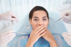 Mujer joven asustada del examen dental fotografía de archivo Mujer joven asustada del examen dental fotografía de archivo