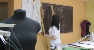 Mujer joven atractiva del diseñador de moda que trabaja en el estudio metrajes Mujer joven atractiva del diseñador de moda que trabaja en el estudio metrajes