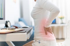 Mujer joven con el dolor de espalda que trabaja con el ordenador Atención sanitaria y concepto médico imagen de archivo libre de regalías Mujer joven con el dolor de espalda que trabaja con el ordenador Atención sanitaria y concepto médico imagen de archivo libre de regalías