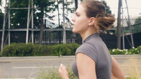 Mujer joven de la aptitud del retrato que corre en la sacudida de la mañana en la calle del verano almacen de metraje de vídeo Mujer joven de la aptitud del retrato que corre en la sacudida de la mañana en la calle del verano almacen de metraje de vídeo