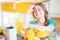 Mujer joven de la aptitud que bebe el smoothie anaranjado en cocina fotos de archivo Mujer joven de la aptitud que bebe el smoothie anaranjado en cocina fotos de archivo