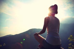 Mujer joven de la yoga en la montaña de la salida del sol fotografía de archivo Mujer joven de la yoga en la montaña de la salida del sol fotografía de archivo