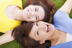 Mujer joven del placer de dos asiáticos que miente en hierba imagen de archivo Mujer joven del placer de dos asiáticos que miente en hierba imagen de archivo