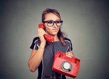 Mujer joven descontentada gruñona que tiene conversación telefónica desagradable imagenes de archivo Mujer joven descontentada gruñona que tiene conversación telefónica desagradable imagenes de archivo