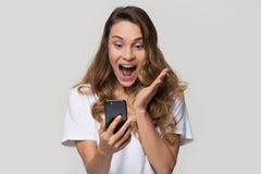 Mujer joven emocionada sorprendente por venta móvil increíble del app que hace compras imagenes de archivo Mujer joven emocionada sorprendente por venta móvil increíble del app que hace compras imagenes de archivo