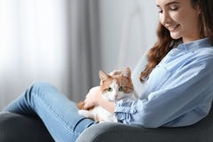 Mujer joven hermosa con el gato lindo en butaca fotos de archivo libres de regalías Mujer joven hermosa con el gato lindo en butaca fotos de archivo libres de regalías