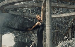 Mujer joven hermosa en el vestido de noche negro que sostiene la tela negra en el viento imagen de archivo libre de regalías Mujer joven hermosa en el vestido de noche negro que sostiene la tela negra en el viento imagen de archivo libre de regalías