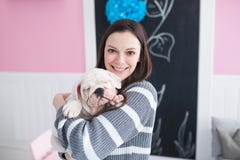 Mujer joven hermosa que sostiene un dogo del inglés del perrito Foto de archivo Mujer joven hermosa que sostiene un dogo del inglés del perrito Foto de archivo