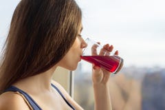 Mujer joven que bebe el jugo fresco natural de un vidrio, primer de la baya foto de archivo Mujer joven que bebe el jugo fresco natural de un vidrio, primer de la baya foto de archivo