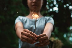 mujer joven que sostiene el fuego artificial de la vela Fotografía de archivo libre de regalías mujer joven que sostiene el fuego artificial de la vela Fotografía de archivo libre de regalías