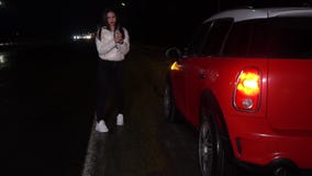 Mujer linda en la chaqueta blanca, intentando parar los coches en una carretera para conseguir una cierta ayuda almacen de video Mujer linda en la chaqueta blanca, intentando parar los coches en una carretera para conseguir una cierta ayuda almacen de video