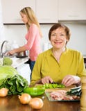 Mujer madura feliz con la hija adulta que cocina junto imágenes de archivo libres de regalías Mujer madura feliz con la hija adulta que cocina junto imágenes de archivo libres de regalías