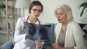 Mujer mayor de la visita auxiliar del doctor en su casa y la mirada encendido almacen de metraje de vídeo Mujer mayor de la visita auxiliar del doctor en su casa y la mirada encendido almacen de metraje de vídeo