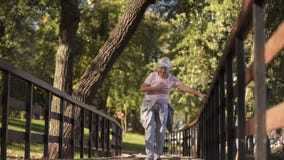 Mujer mayor que corre en el parque, angustia sufridora, problema de salud en una más vieja edad foto de archivo libre de regalías Mujer mayor que corre en el parque, angustia sufridora, problema de salud en una más vieja edad foto de archivo libre de regalías