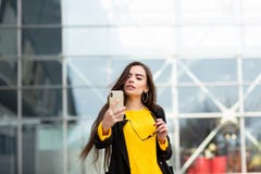 Mujer morena alegre en el su?ter amarillo que hace el sefie contra fondo del aeropuerto Tecnolog?a moderna foto de archivo Mujer morena alegre en el su?ter amarillo que hace el sefie contra fondo del aeropuerto Tecnolog?a moderna foto de archivo