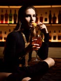 Mujer morena de la moda atractiva hermosa en cóctel anaranjado de consumición de relajación del sprit del aperol del restaurante fotografía de archivo libre de regalías Mujer morena de la moda atractiva hermosa en cóctel anaranjado de consumición de relajación del sprit del aperol del restaurante fotografía de archivo libre de regalías
