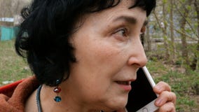 Mujer morena elegante adulta que habla emocionalmente en su smartphone Mujer morena elegante adulta que habla emocionalmente en su smartphone