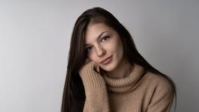 Mujer morena joven magnífica en suéter hecho punto caliente en fondo gris claro fotos de archivo libres de regalías Mujer morena joven magnífica en suéter hecho punto caliente en fondo gris claro fotos de archivo libres de regalías