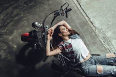 Mujer morena joven sensual que presenta en la motocicleta imagen de archivo Mujer morena joven sensual que presenta en la motocicleta imagen de archivo