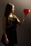 Mujer preciosa con la caja de regalo en forma de corazón roja Imagenes de archivo Mujer preciosa con la caja de regalo en forma de corazón roja Imagenes de archivo