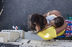 Mujer que amamanta a un niño que vende velas en la yarda de la iglesia Fotos de archivo libres de regalías Mujer que amamanta a un niño que vende velas en la yarda de la iglesia Fotos de archivo libres de regalías