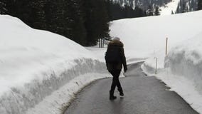 Mujer que camina en el camino en las montañas almacen de metraje de vídeo Mujer que camina en el camino en las montañas almacen de metraje de vídeo
