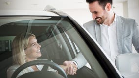 Mujer que compra un coche en la representación que se sienta en su nuevo auto foto de archivo libre de regalías Mujer que compra un coche en la representación que se sienta en su nuevo auto foto de archivo libre de regalías