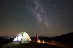 Mujer que descansa en la noche que acampa en monta?as debajo del cielo estrellado imágenes de archivo libres de regalías Mujer que descansa en la noche que acampa en monta?as debajo del cielo estrellado imágenes de archivo libres de regalías