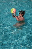 Mujer que juega con la bola en una piscina foto de archivo Mujer que juega con la bola en una piscina foto de archivo