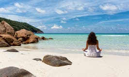 Mujer que realiza yoga en una playa tropical fotos de archivo Mujer que realiza yoga en una playa tropical fotos de archivo