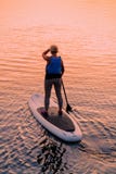 Mujer que se levanta en el barco de paleta en el lago Trakai galve fotos de archivo Mujer que se levanta en el barco de paleta en el lago Trakai galve fotos de archivo