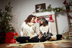Mujer que se sienta cerca del árbol de navidad con su hija fotografía de archivo Mujer que se sienta cerca del árbol de navidad con su hija fotografía de archivo