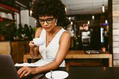 Mujer que se sienta en café con un ordenador portátil fotografía de archivo libre de regalías Mujer que se sienta en café con un ordenador portátil fotografía de archivo libre de regalías