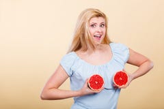 Mujer que sostiene el pomelo rojo en el pecho Imagen de archivo Mujer que sostiene el pomelo rojo en el pecho Imagen de archivo
