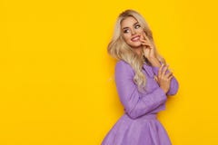 Mujer rubia de Beuatiful en Violet Costume Is Smiling And que mira el espacio amarillo de la copia Fotografía de archivo libre de regalías Mujer rubia de Beuatiful en Violet Costume Is Smiling And que mira el espacio amarillo de la copia Fotografía de archivo libre de regalías