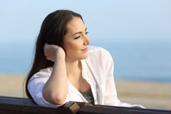 Mujer satisfecha pensativa que mira lejos en la playa imagen de archivo libre de regalías Mujer satisfecha pensativa que mira lejos en la playa imagen de archivo libre de regalías