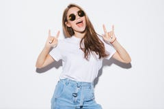 Mujer sensual de la moda joven bonita que presenta en el fondo blanco de la pared vestido en equipo de los vaqueros del estilo In imagen de archivo Mujer sensual de la moda joven bonita que presenta en el fondo blanco de la pared vestido en equipo de los vaqueros del estilo In imagen de archivo